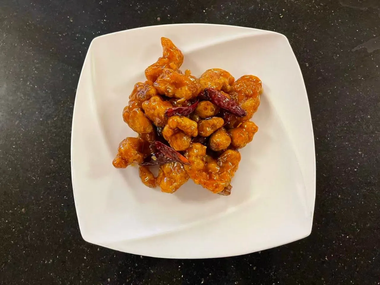 Spicy glazed fried meat topped with dried red chili peppers